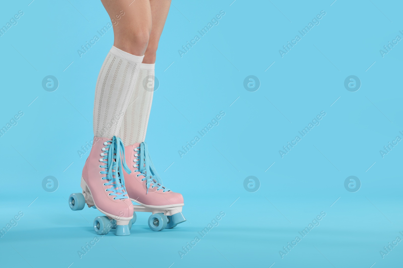 Woman in roller skates on light blue background, closeup. Space for text Photo of Woman in roller skates on light blue background, closeup. Space for text