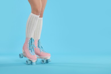 Photo of Woman in roller skates on light blue background, closeup. Space for text