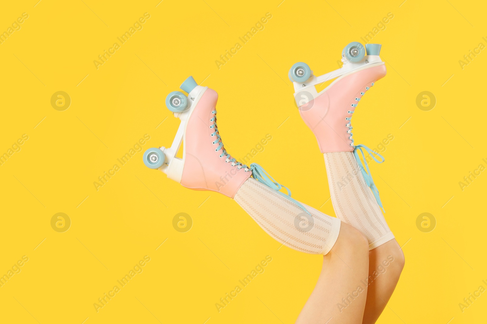 Woman in roller skates on orange background, closeup. Space for text Photo of Woman in roller skates on orange background, closeup. Space for text