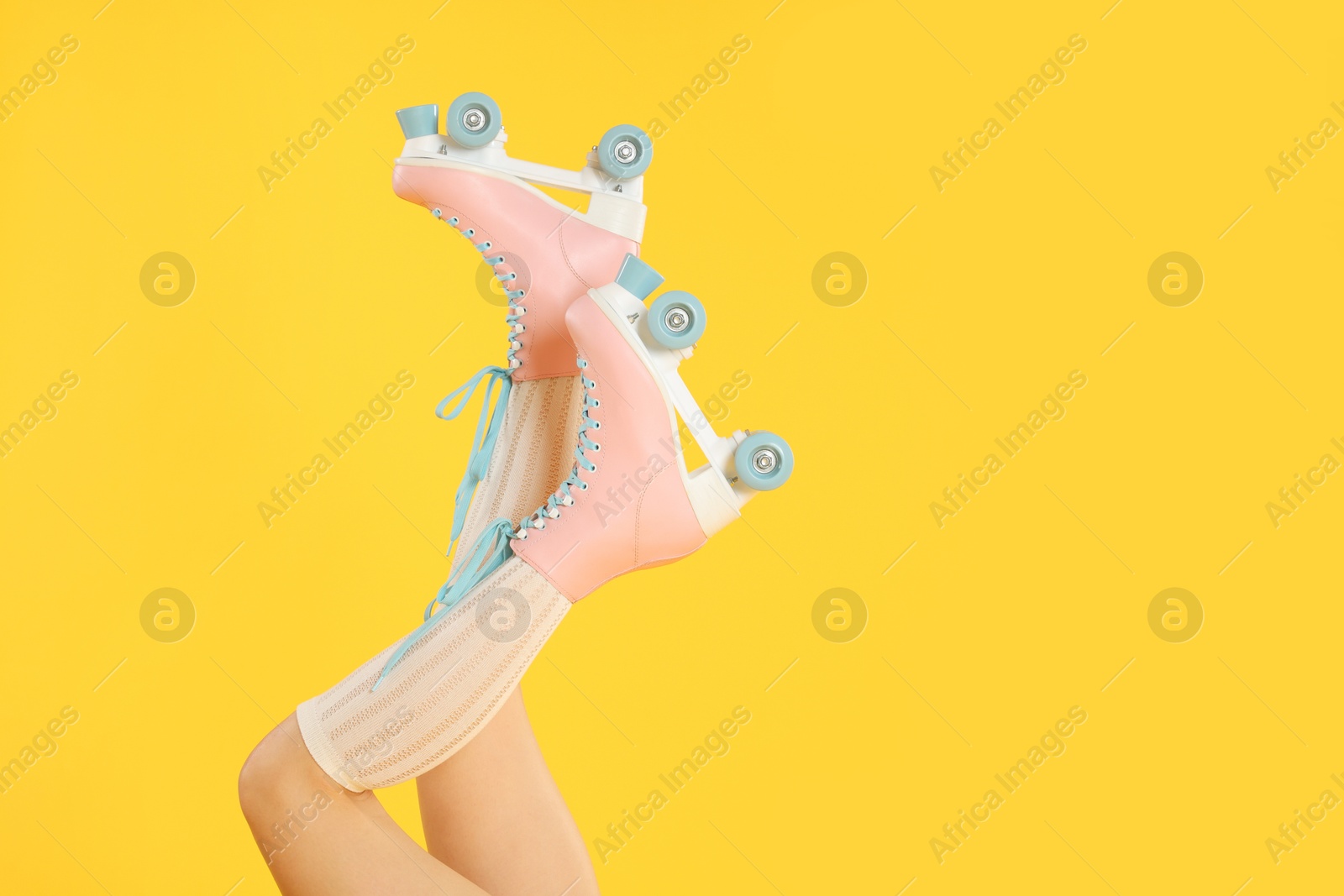 Woman in roller skates on orange background, closeup. Space for text Photo of Woman in roller skates on orange background, closeup. Space for text