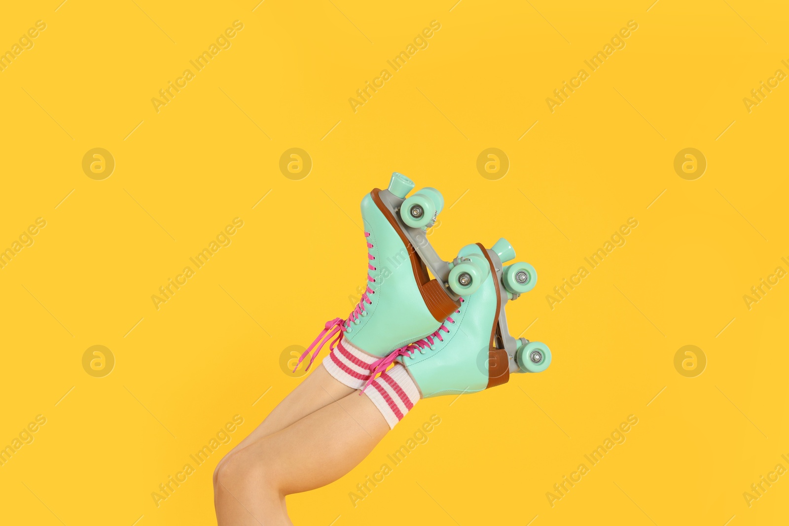 Woman in roller skates on orange background, closeup Photo of Woman in roller skates on orange background, closeup