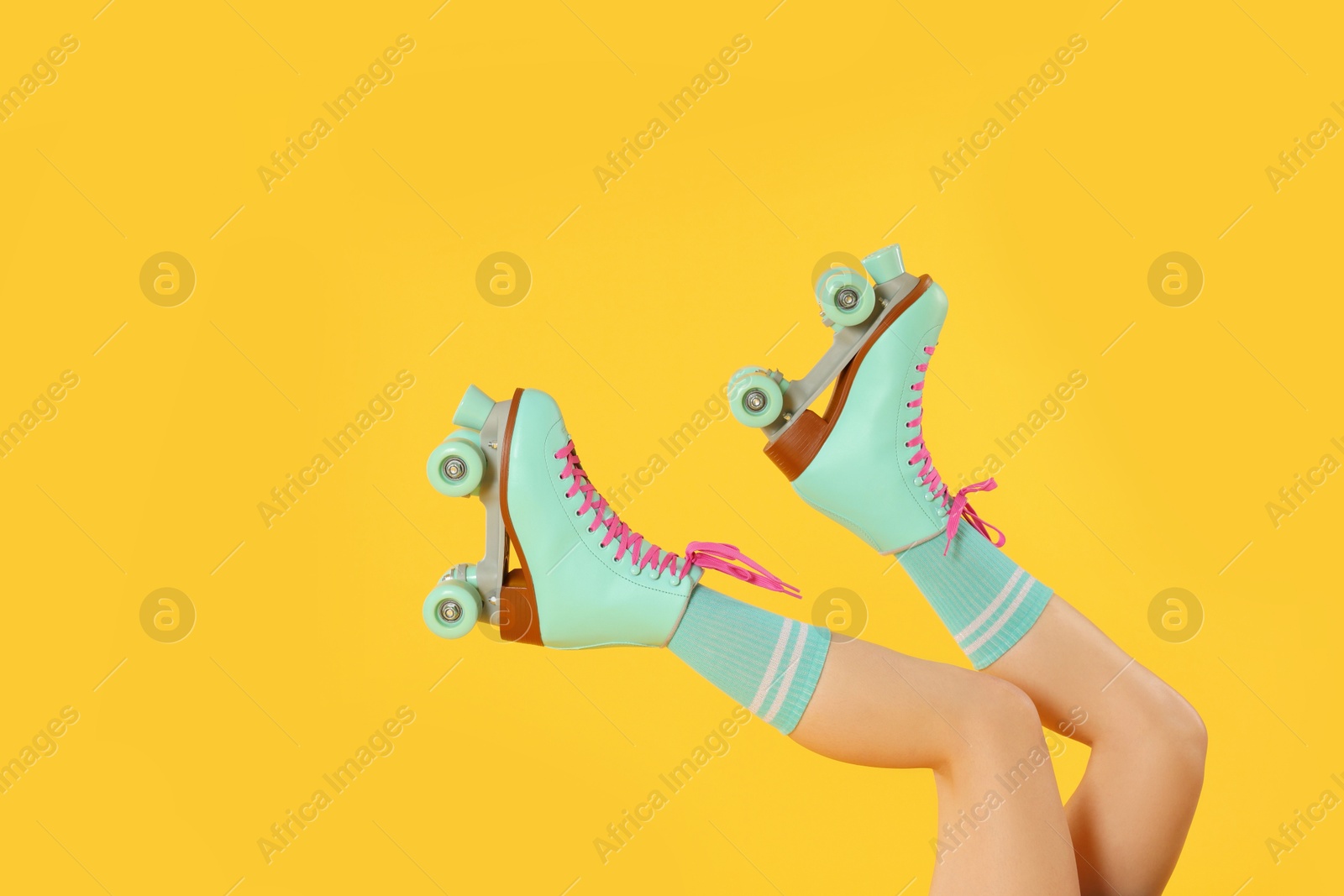 Woman in roller skates on orange background, closeup, space for text Photo of Woman in roller skates on orange background, closeup, space for text