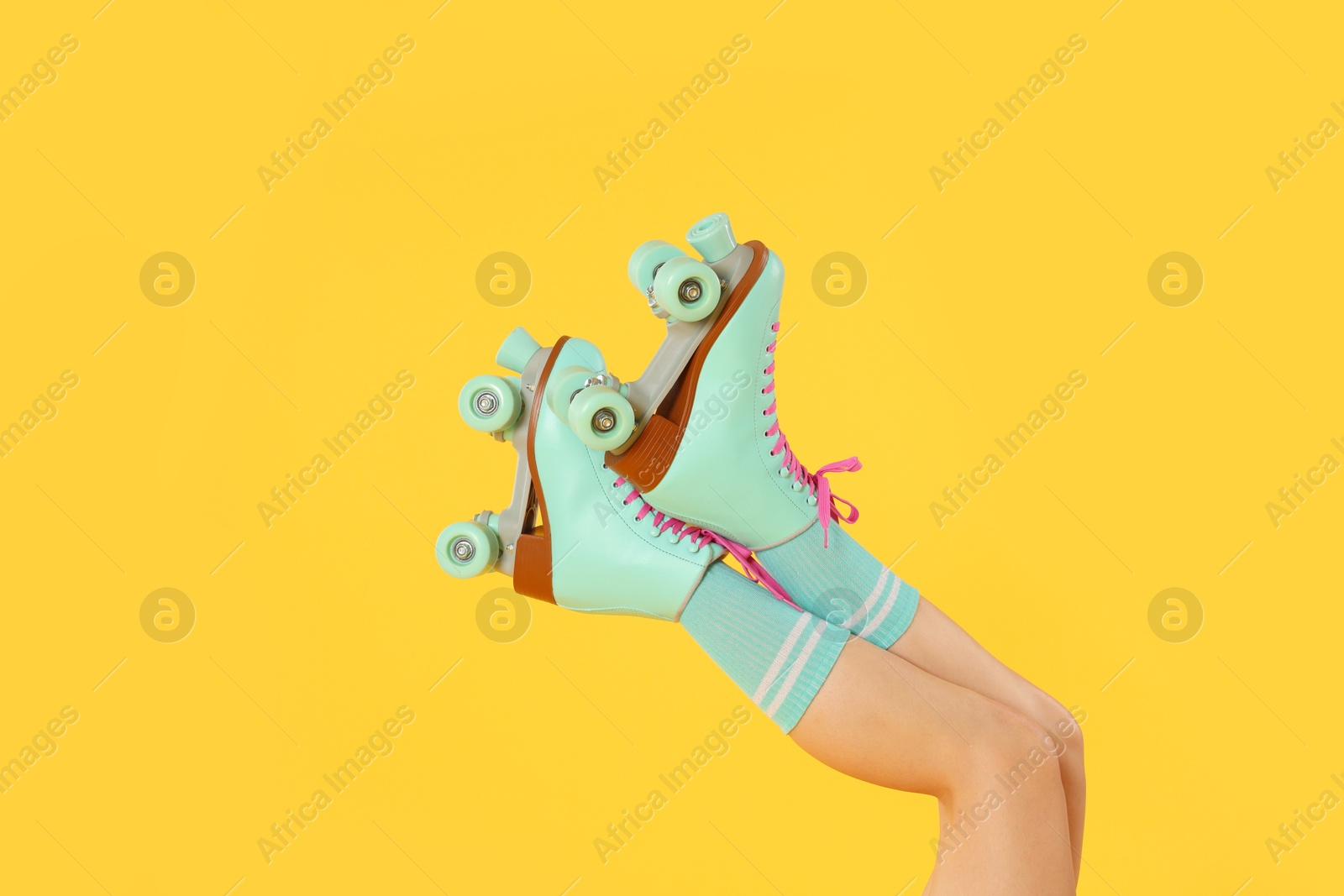 Woman in roller skates on orange background, closeup Photo of Woman in roller skates on orange background, closeup