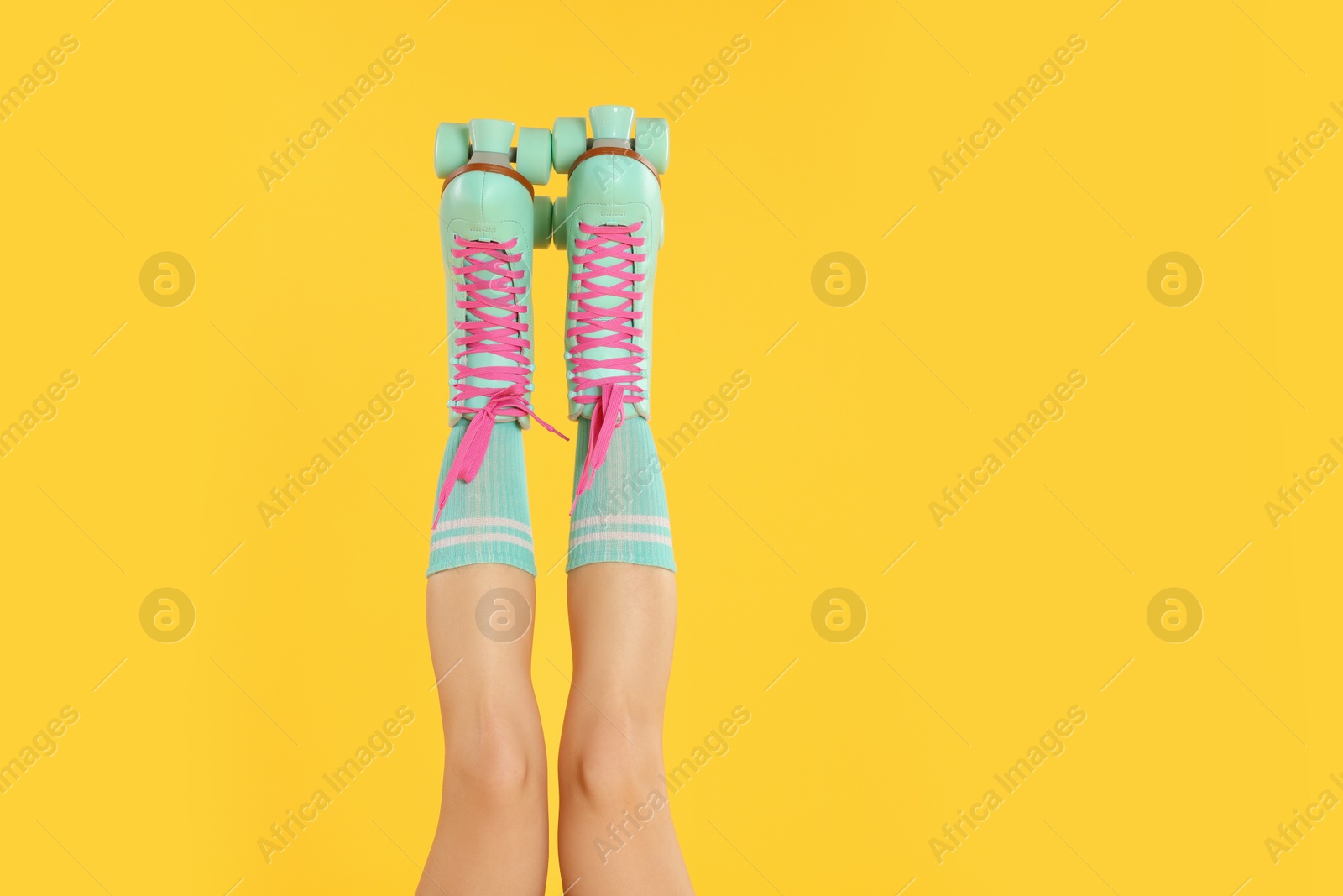 Woman in roller skates on orange background, closeup Photo of Woman in roller skates on orange background, closeup