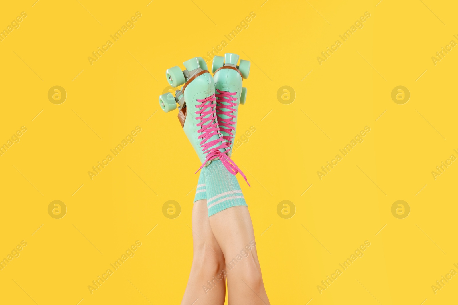 Woman in roller skates on orange background, closeup Photo of Woman in roller skates on orange background, closeup