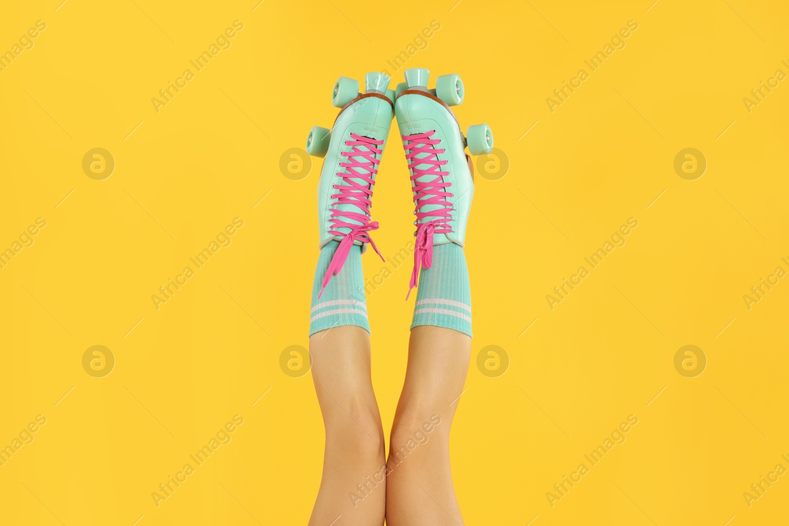 Woman in roller skates on orange background, closeup Photo of Woman in roller skates on orange background, closeup