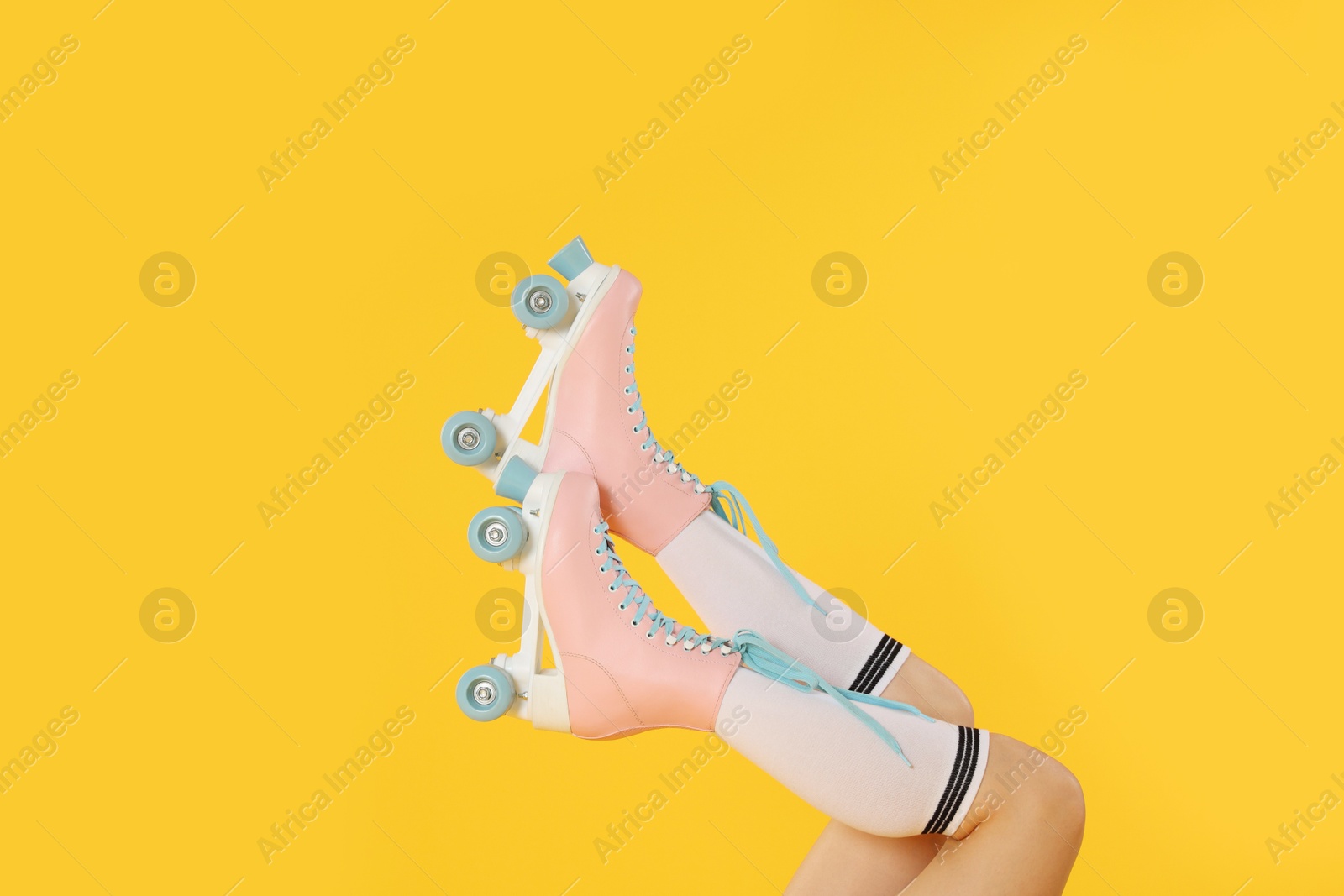 Woman in roller skates on orange background, closeup Photo of Woman in roller skates on orange background, closeup