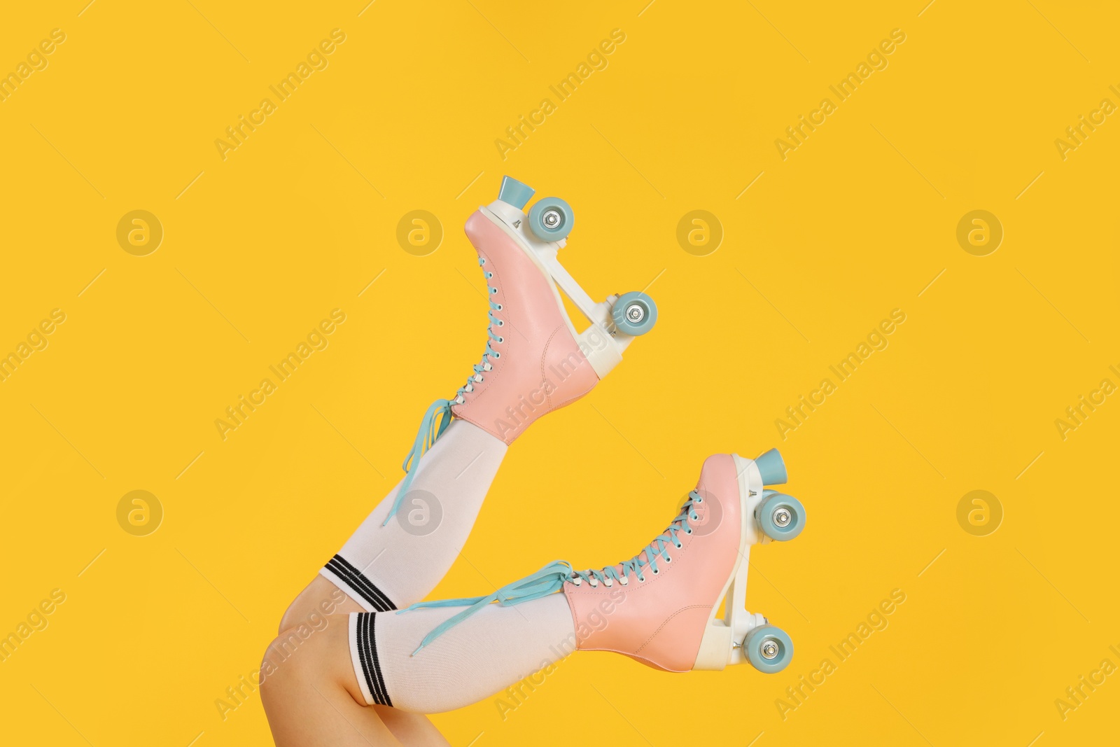 Woman in roller skates on orange background, closeup Photo of Woman in roller skates on orange background, closeup