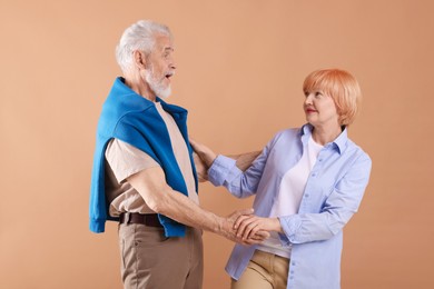Photo of Lovely senior couple together on light brown background