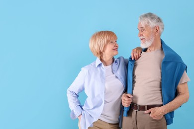 Photo of Lovely senior couple together on light blue background, space for text