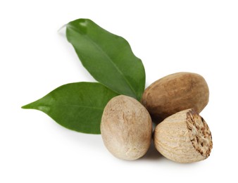 Photo of Whole, cut nutmegs and leaves isolated on white