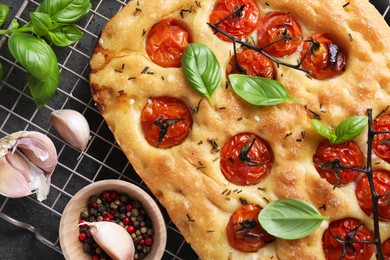 Photo of Delicious focaccia with tomatoes and spices on table, flat lay