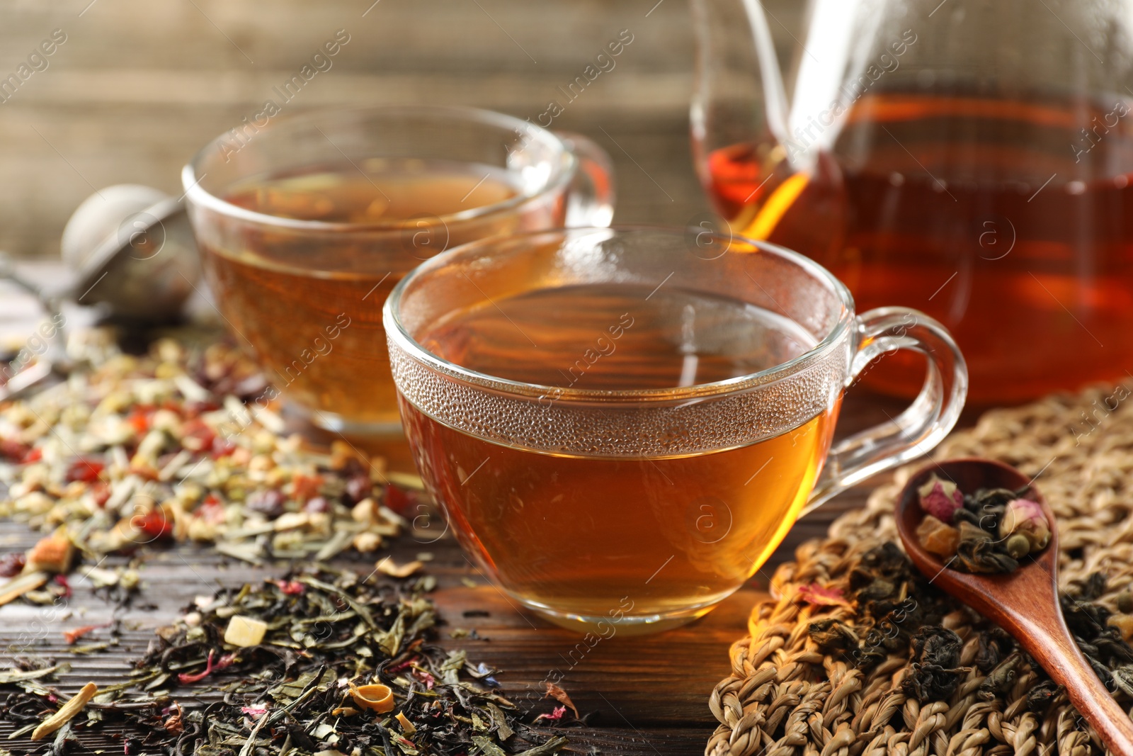 Refreshing herbal tea and dry leaves on wooden table, closeup Photo of Refreshing herbal tea and dry leaves on wooden table, closeup