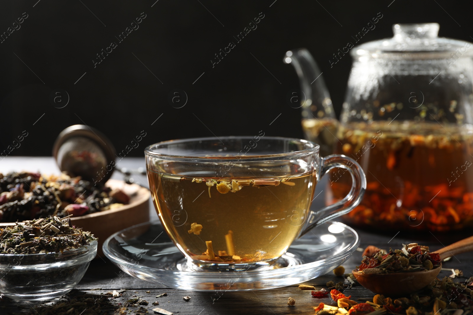 Refreshing herbal tea and dry leaves on black wooden table, closeup. Space for text Photo of Refreshing herbal tea and dry leaves on black wooden table, closeup. Space for text