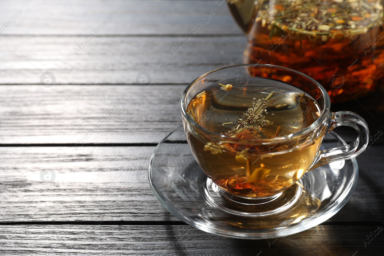 Refreshing herbal tea on black wooden table, closeup. Space for text Photo of Refreshing herbal tea on black wooden table, closeup. Space for text