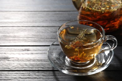 Photo of Refreshing herbal tea on black wooden table, closeup. Space for text