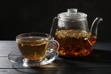 Photo of Refreshing herbal tea on black wooden table