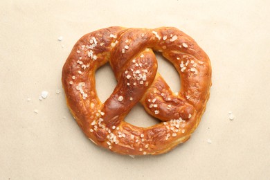 Photo of Tasty pretzels with salt on beige background, top view