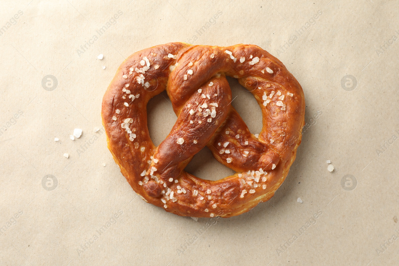 Tasty pretzels with salt on beige background, top view Photo of Tasty pretzels with salt on beige background, top view