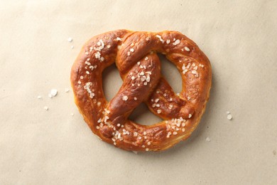 Photo of Tasty pretzels with salt on beige background, top view