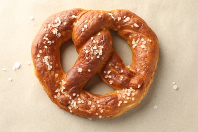 Photo of Tasty pretzels with salt on beige background, top view