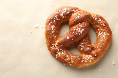 Photo of Tasty pretzels with salt on beige background, top view. Space for text