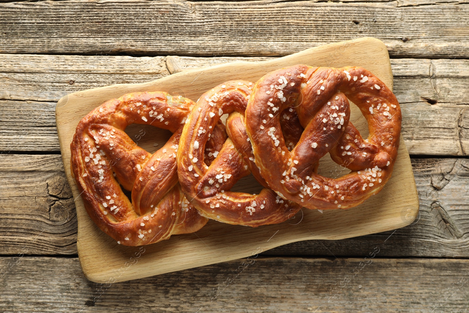 Tasty pretzels with salt on wooden table, top view Photo of Tasty pretzels with salt on wooden table, top view