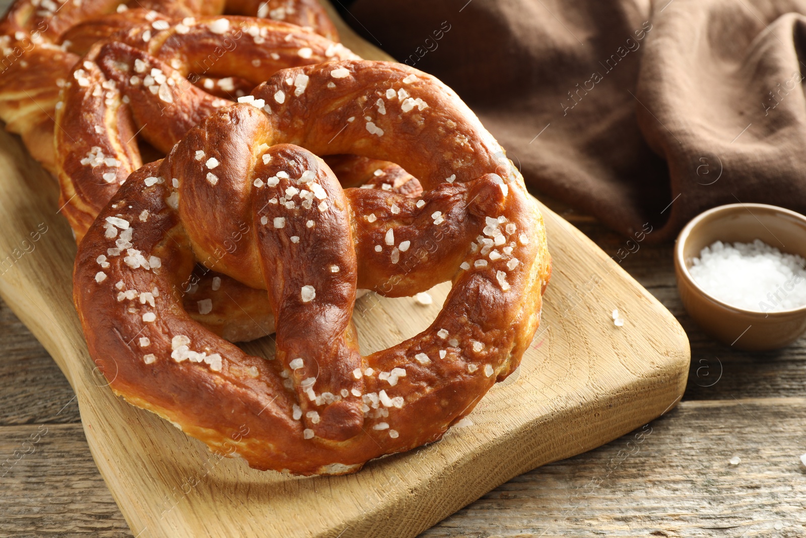Tasty pretzels with salt on wooden table, closeup Photo of Tasty pretzels with salt on wooden table, closeup
