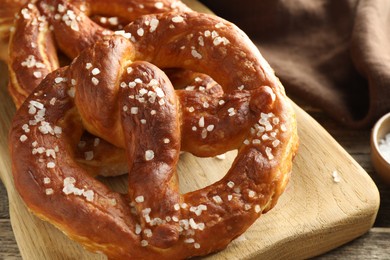 Photo of Tasty pretzels with salt on table, closeup