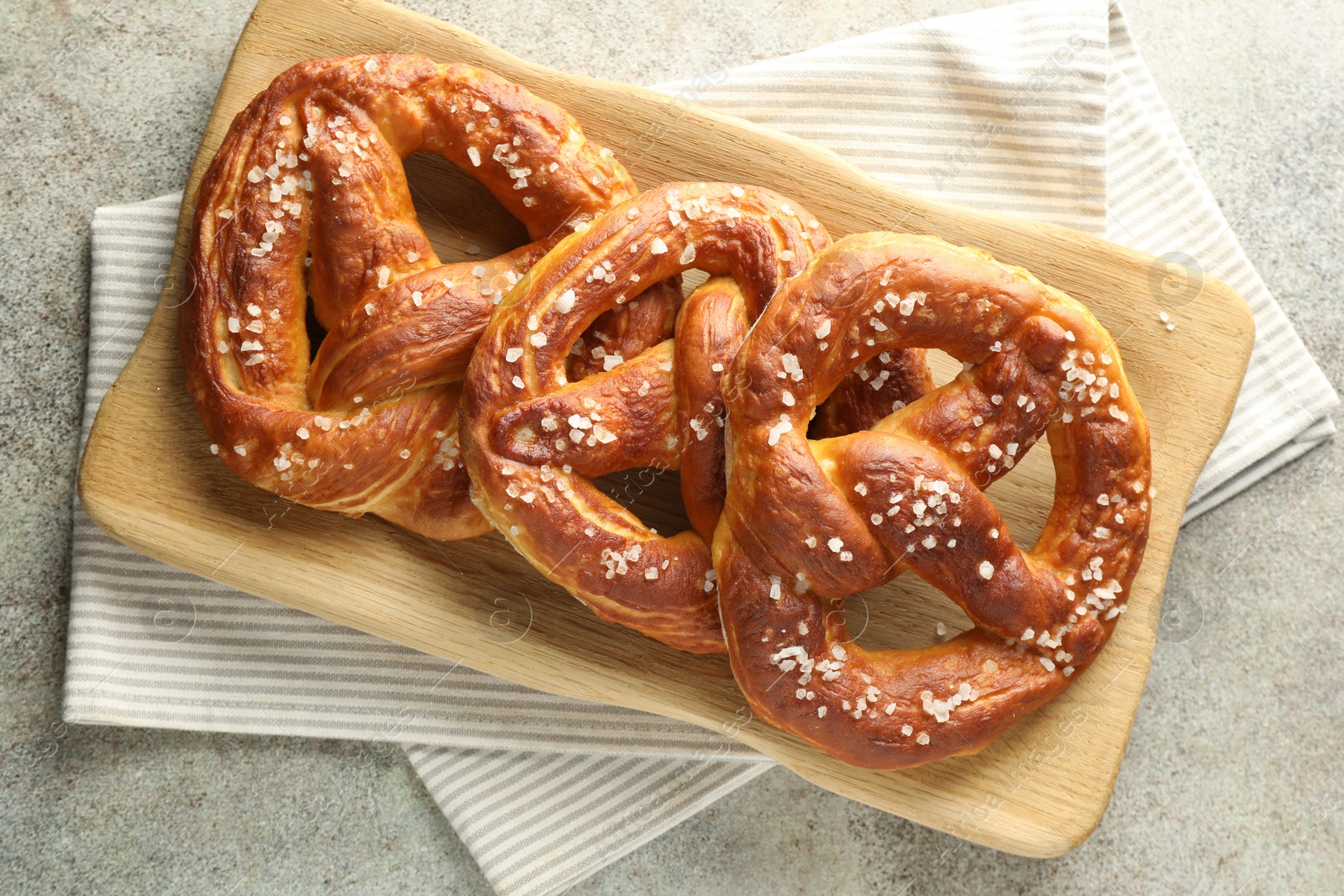 Tasty pretzels with salt on grey table, top view Photo of Tasty pretzels with salt on grey table, top view