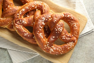 Photo of Tasty pretzels with salt on grey table, top view
