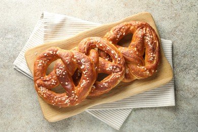 Photo of Tasty pretzels with salt on grey table, top view