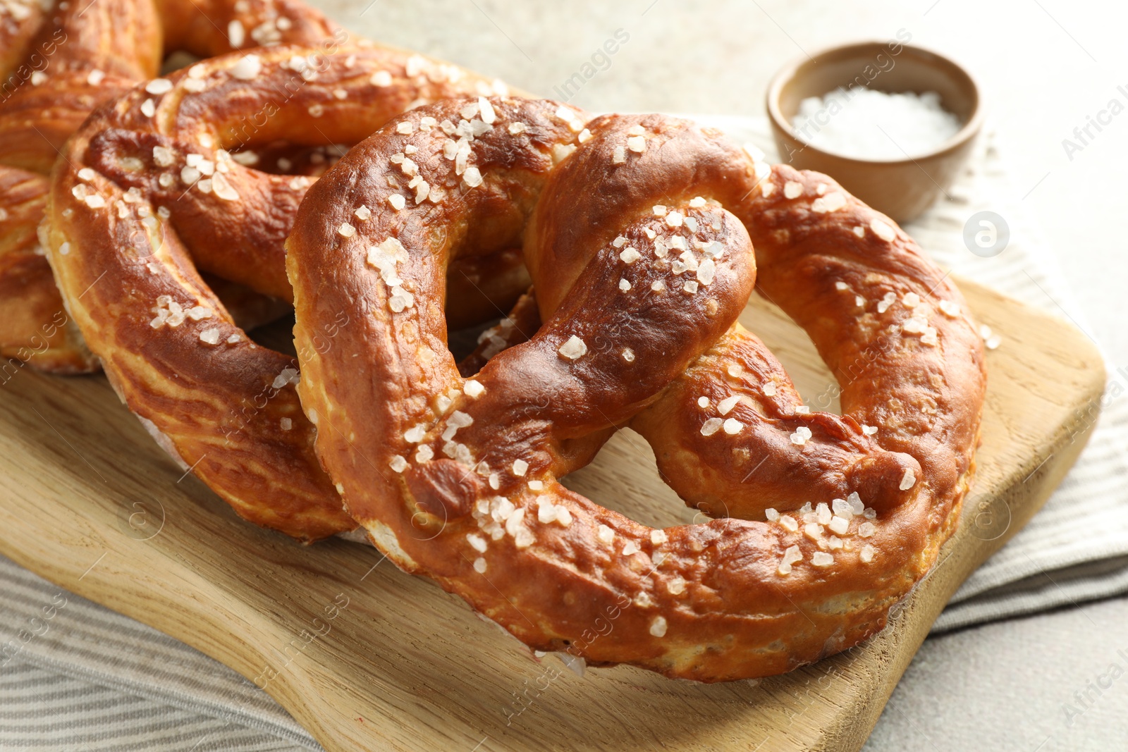 Tasty pretzels with salt on grey table, closeup Photo of Tasty pretzels with salt on grey table, closeup