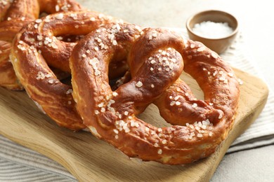 Photo of Tasty pretzels with salt on grey table, closeup