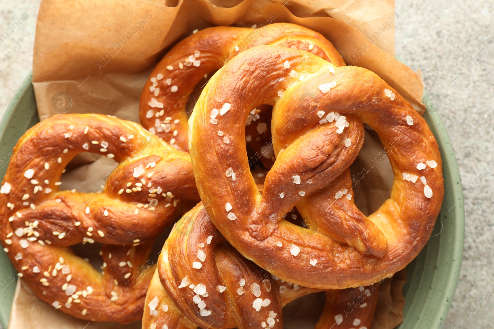 Tasty pretzels with salt on grey table, top view Photo of Tasty pretzels with salt on grey table, top view