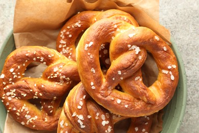 Photo of Tasty pretzels with salt on grey table, top view