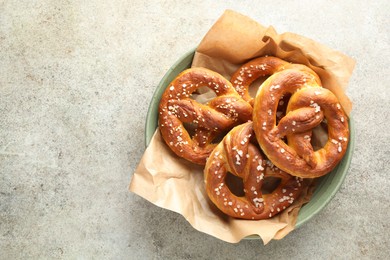 Photo of Tasty pretzels with salt on grey table, top view. Space for text