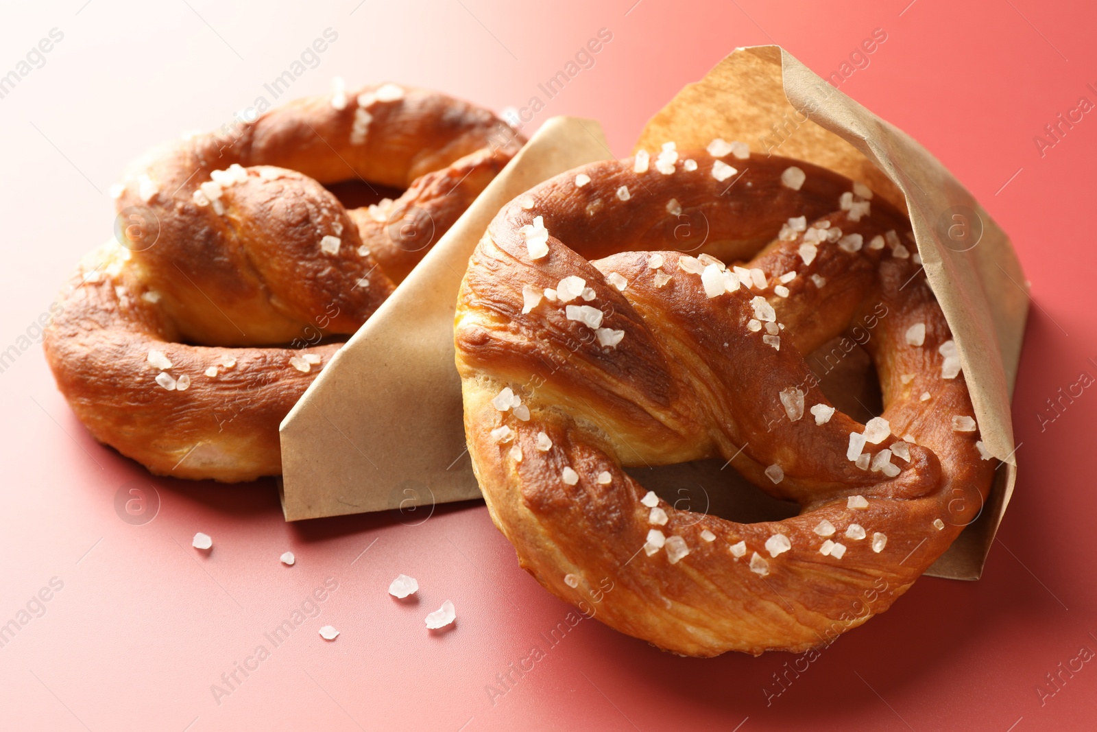 Tasty pretzels with salt on red background, closeup Photo of Tasty pretzels with salt on red background, closeup