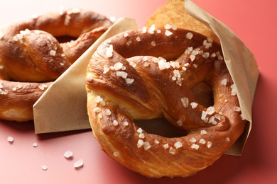 Photo of Tasty pretzels with salt on red background, closeup