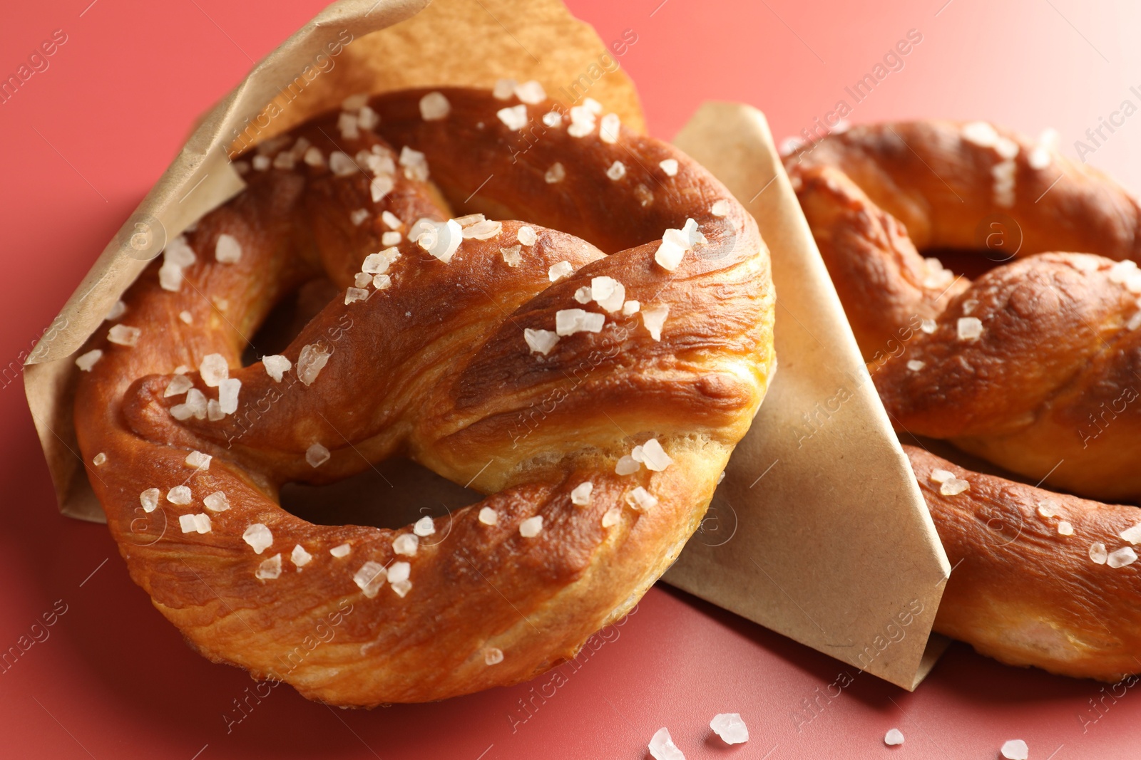 Tasty pretzels with salt on red background, closeup Photo of Tasty pretzels with salt on red background, closeup