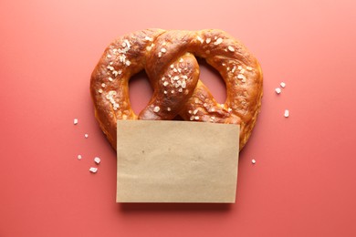 Photo of Tasty pretzel with salt on red background, top view