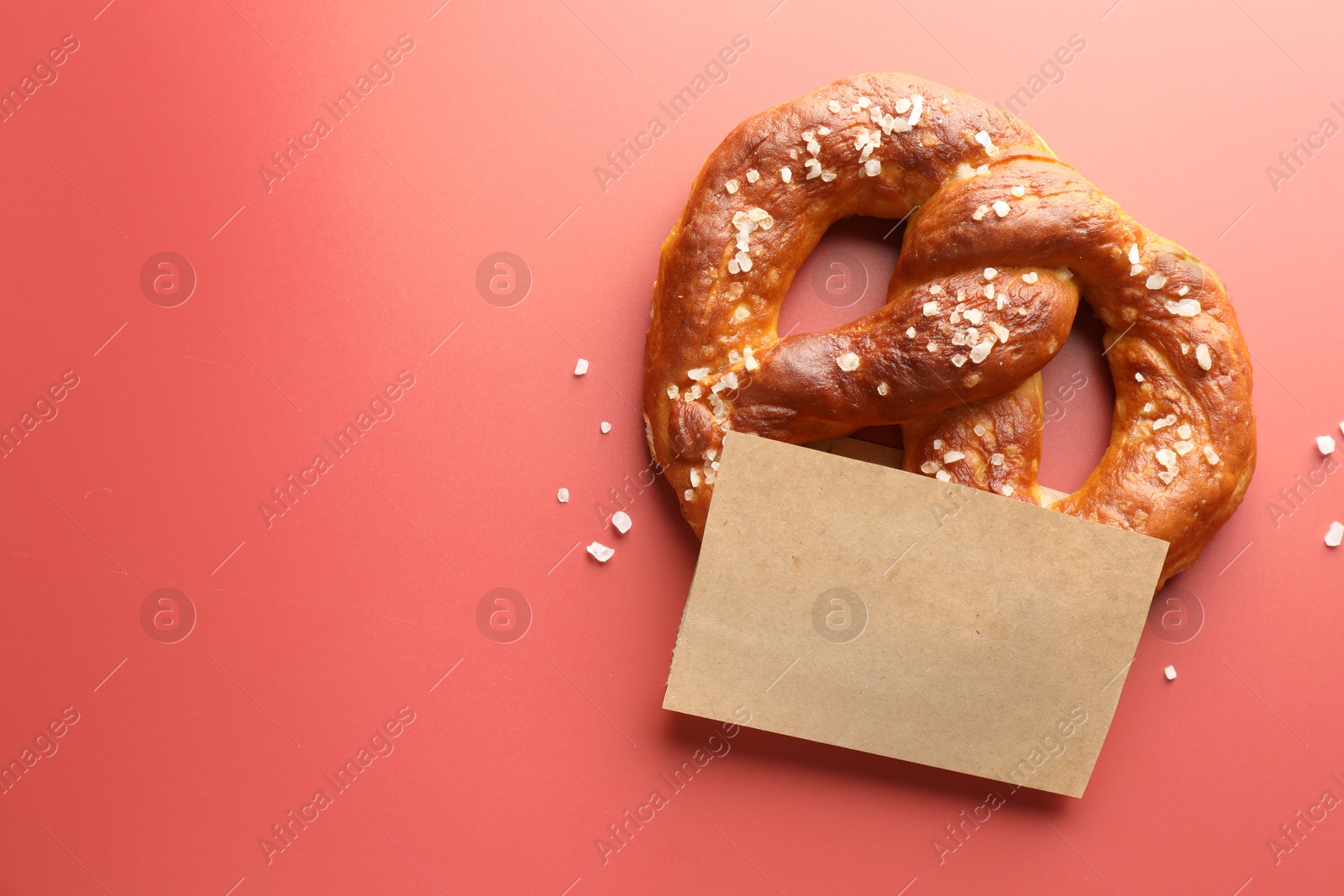Tasty pretzel with salt on red background, top view. Space for text Photo of Tasty pretzel with salt on red background, top view. Space for text