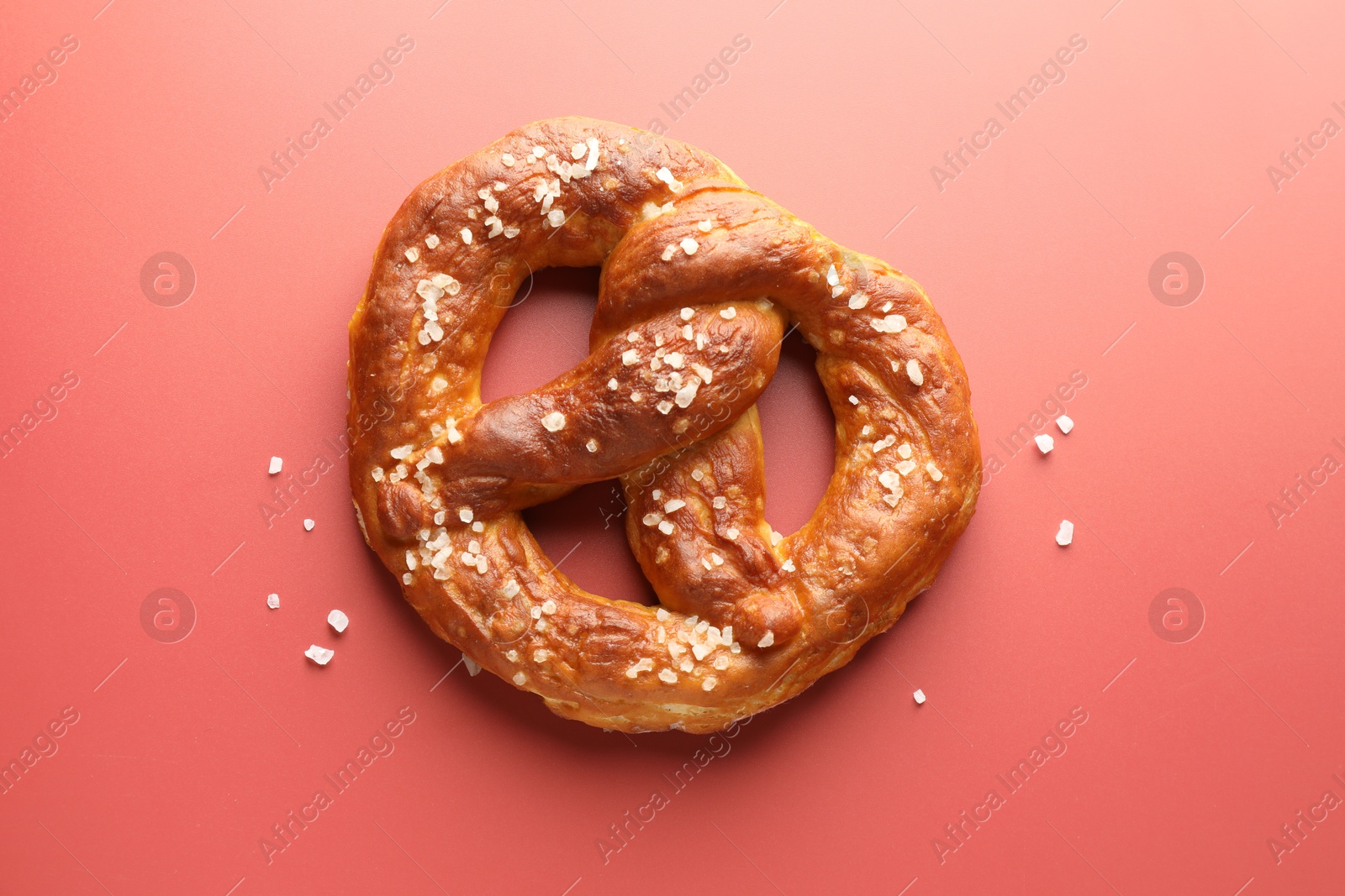 Tasty pretzel with salt on red background, top view Photo of Tasty pretzel with salt on red background, top view