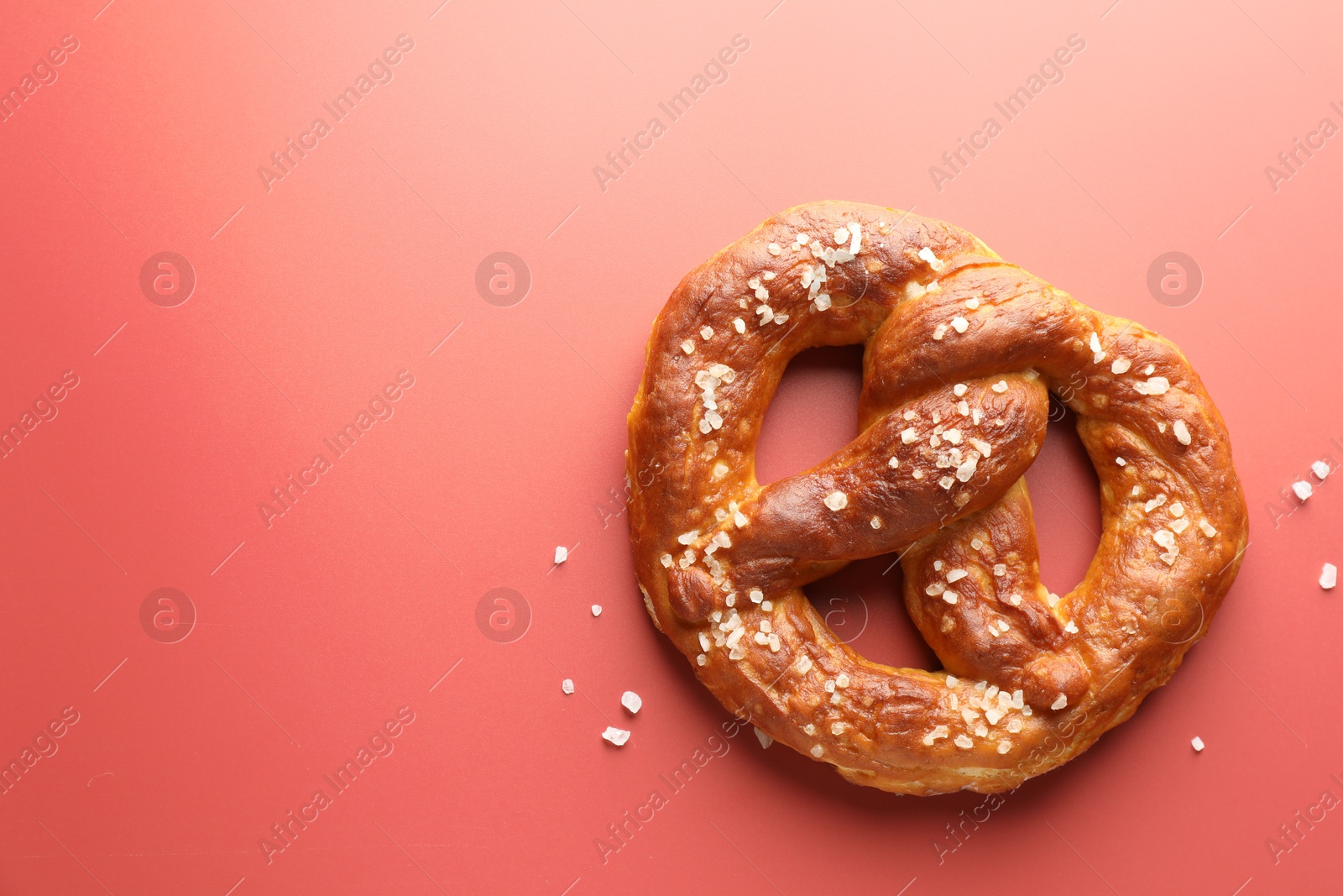 Tasty pretzel with salt on red background, top view. Space for text Photo of Tasty pretzel with salt on red background, top view. Space for text