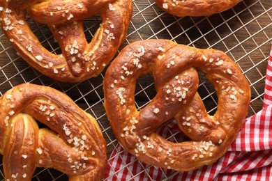 Photo of Tasty pretzels with salt on wooden table, top view