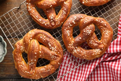 Photo of Tasty pretzels with salt on wooden table, top view