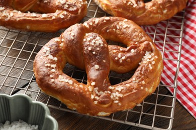 Photo of Tasty pretzels with salt on wooden table, closeup