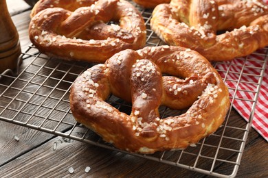 Photo of Tasty pretzels with salt on wooden table, closeup
