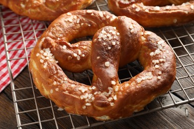 Photo of Tasty pretzels with salt on wooden table, closeup