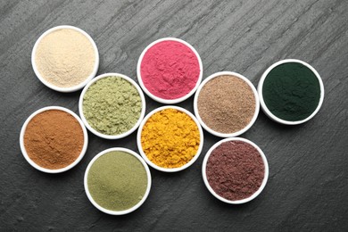 Photo of Different superfood powders on black table, flat lay